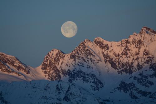 a moonrise over a snow covered mountain range at Hotel Chacaril in Pila