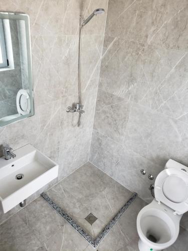 een badkamer met een douche, een toilet en een wastafel bij Villa Luan Ksamil in Ksamil