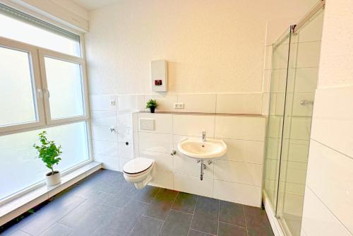 een badkamer met een toilet en een wastafel bij 80qm Apartment in Krefeld zentral gelegen mit hohen Decken - BEUYS Apartments - Krefeld in Krefeld