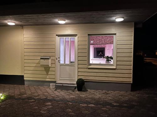 a house with a window and a door with a flower at Hyggelig lejlighed i Rinkenæs in Gråsten