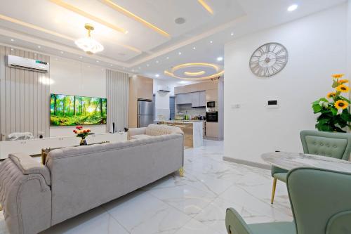 a living room with a couch and a clock on the wall at Cecilia Homes in Lekki
