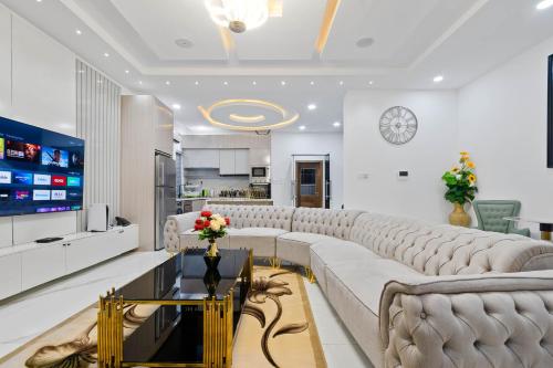 a living room with a large couch and a tv at Cecilia Homes in Lekki