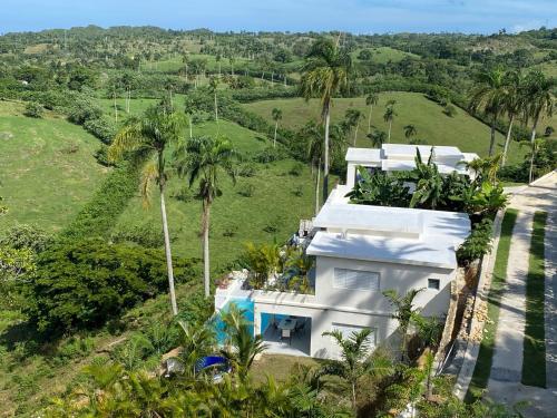 an aerial view of a white house with palm trees at Piscina vista al mar, Jacuzzi con agua caliente in Río San Juan
