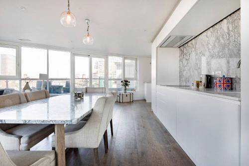 a kitchen and dining room with a table and chairs at Luxury Panoramic 3 bed with private terrace in London