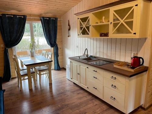 a kitchen with a table and a sink and a table and a tablektop at Restauracja i Noclegi Izba Rybacka w Krainie Wygasłych Wulkanów in Podgórki