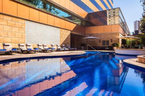 una piscina con sillas junto a un edificio en Santiago Marriott Hotel, en Santiago