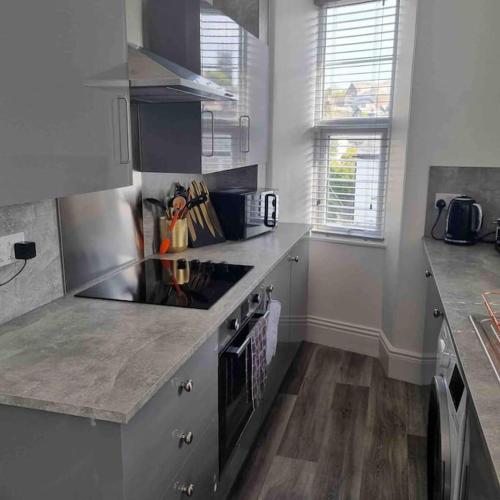 a kitchen with a stove and a counter top at First floor apartment in Stratton, Bude in Stratton