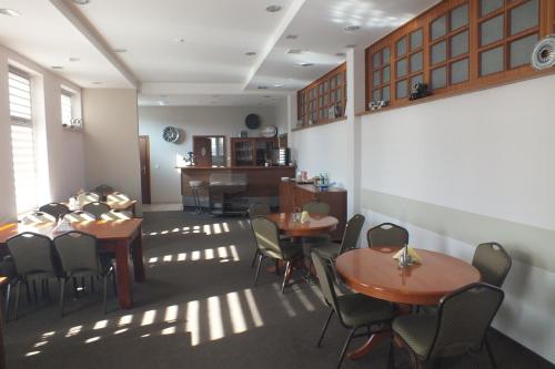 restauracja ze stołami i krzesłami w pokoju w obiekcie Motel Subaru w Warszawie