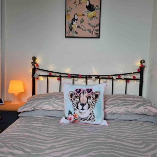 a bedroom with a cheetah pillow on a bed at First floor apartment in Stratton, Bude in Stratton