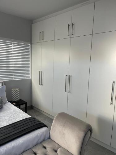 a white bedroom with a bed and white cabinets at Kensington Palace in Dowerville