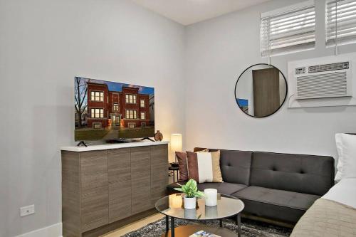 Una sala de estar con un sofá y un espejo. en Comfortable & Furnished Studio Apt with Wi-Fi - Magnolia CH, en Chicago