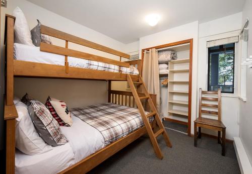 a bunk bed room with two bunk beds and a ladder at Amazing Village Location with PRIVATE Hot Tub in Whistler