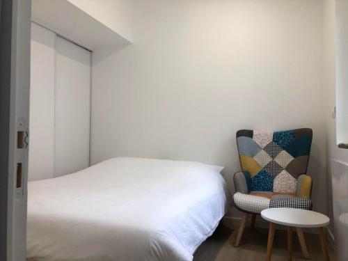 1 dormitorio pequeño con 1 cama y 1 silla en F2 équipé, 15mn de Paris, parking, climatisation, en Bourg-la-Reine