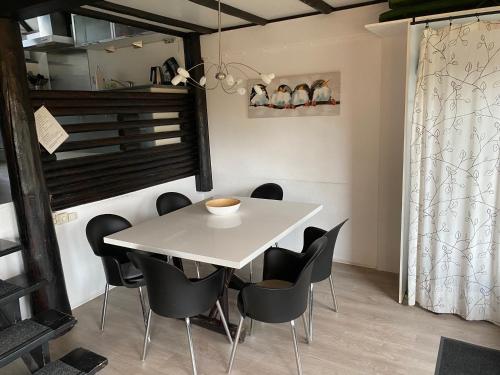 ein Esszimmer mit einem weißen Tisch und schwarzen Stühlen in der Unterkunft Frankenau 36 in Frankenau