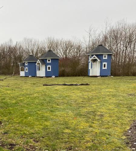 three blue houses in a field of grass at Kroghs Tiny Houses - Hyttebyen in Grindsted