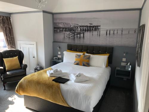 a bedroom with a large bed and a chair at Swanage Haven Boutique Guest House in Swanage