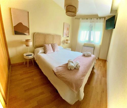 1 dormitorio con 1 cama con 2 toallas en TuristHome Greco, en Sarria