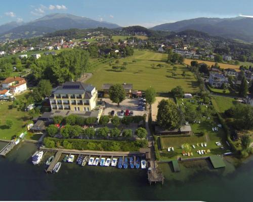 eine Luftansicht eines großen Hauses mit Park in der Unterkunft Strandhotel Pichler in Seeboden