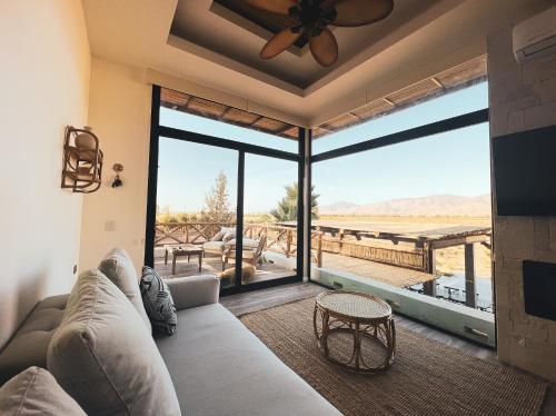 a living room with a couch and a large window at Penthouse at Hotel Boutique Valle de Guadalupe in Valle de Guadalupe