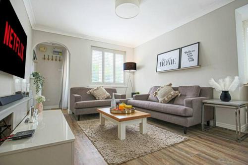 ein Wohnzimmer mit 2 Sofas und einem Tisch in der Unterkunft Lowndes House - Close to City Centre - Garden, Free Parking and Smart TV by Yoko Property in Milton Keynes