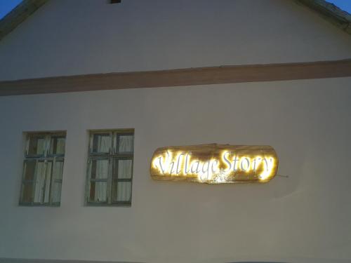 um sinal na lateral de um edifício branco em Village Story kuća za odmor Plavna 