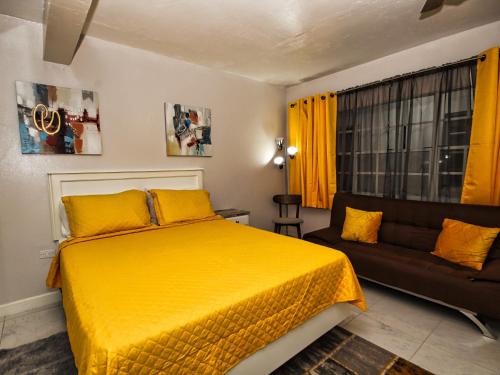 een slaapkamer met een geel bed en een bank bij The Castle in Philipsburg
