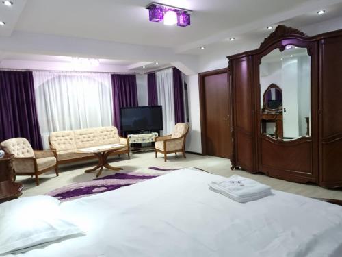 um quarto de hotel com uma cama grande e uma televisão em PENSIUNEA LUXURY em Vama