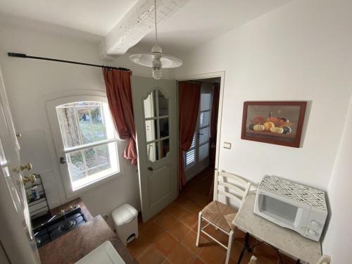 - un salon avec une table et un four micro-ondes dans l'établissement Pavillon Cassis, à Cassis