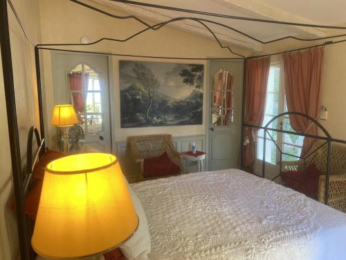 une chambre avec un lit avec une lampe et un tableau dans l'établissement Pavillon Cassis, à Cassis