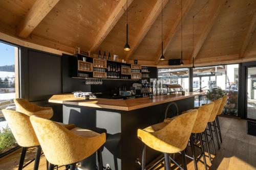a bar in a restaurant with yellow stools at Landhotel Berger in Eben im Pongau