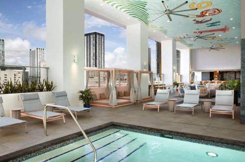 a rooftop patio with a pool and chairs and a clock at Exceptional Studio with King Bed and Queen Sofa-bed in Miami
