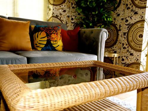 a living room with a wicker chair and a couch at Deluxe 4 5 Bed Hot Tub Cinema Room 15 in Saffron Walden