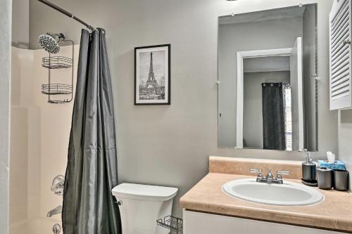 a bathroom with a sink and a toilet and a mirror at Updated Fayetville Townhome-Away-From-Home with Yard in Fayetteville