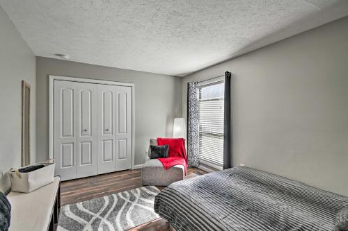 a bedroom with a bed and a red chair at Updated Fayetville Townhome-Away-From-Home with Yard in Fayetteville