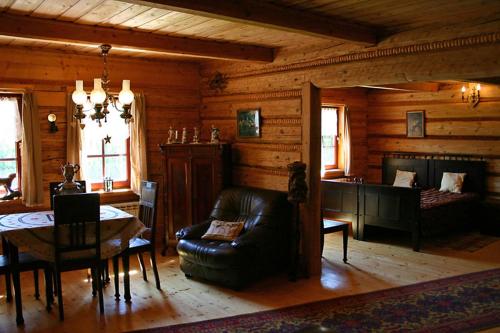 a living room with a leather couch and a table at Dworek Myśliwski in Laskówka