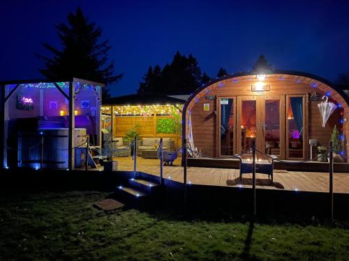 una casa circolare con un cortile illuminato di notte di FINN VILLAGE - Loch Lomond Sunset Glamping Pod - Private Ofuro HOT TUB a Drymen