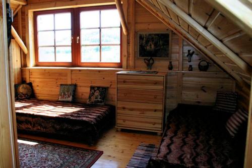 a room with a bed and a window in a cabin at Dworek Myśliwski in Laskówka