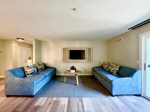 a living room with two blue couches and a tv at The Villages at Ocean Edge Resort & Golf Club in Brewster