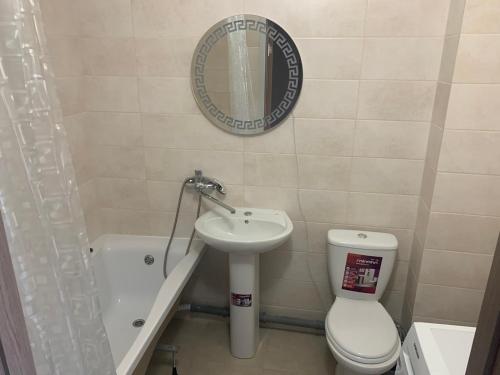 a bathroom with a sink and a toilet and a mirror at Квартира ЖК 7 Небо Одесса Аквапарк Рынок-7 in Odesa