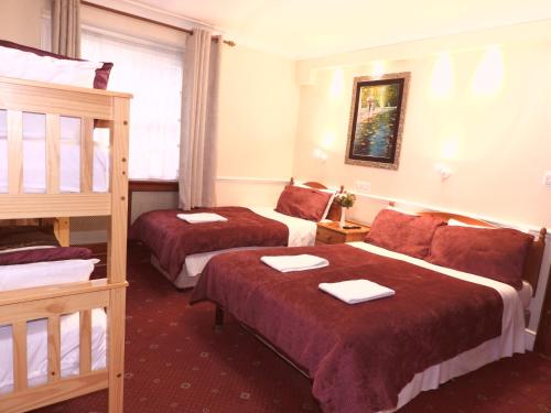 a hotel room with two beds and a bunk bed at Europa House Hotel, London Paddington in London