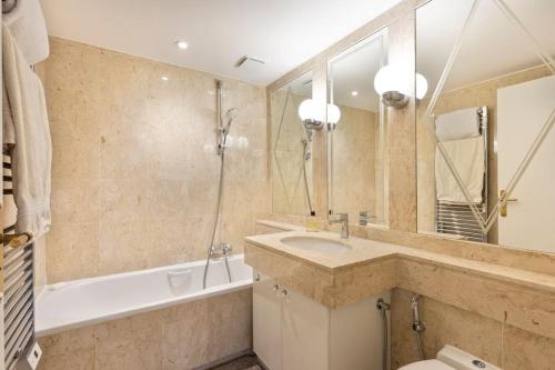 y baño con lavabo, bañera y espejo. en croisette3bedroomterrasse, en Cannes