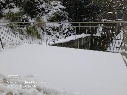 a fence covered in snow next to a gate at Villa Eva I in Nédhousa