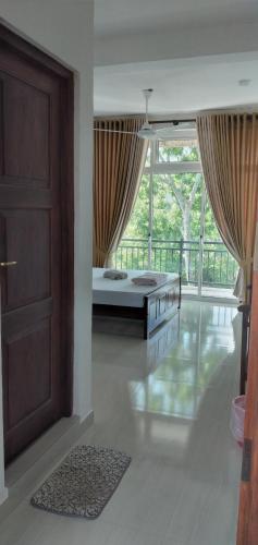 a large room with a door and a balcony at Lanka Villas Holiday Resort in Kandy