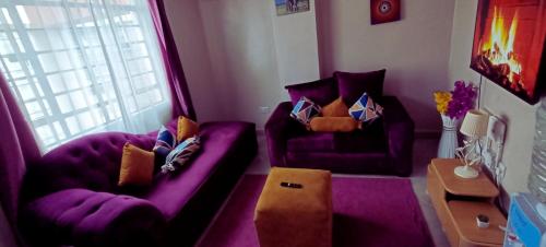 uma sala de estar com mobiliário roxo e um sofá roxo em The Purple Gem Airbnb -South B- Oak South Apartments em Nairobi