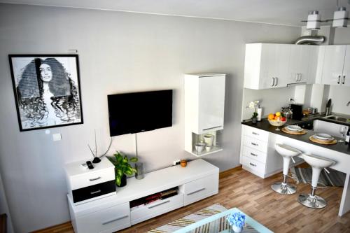 a white living room with a tv on a wall at Морски Бриз in Varna City