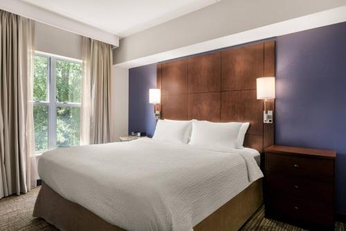 a bedroom with a large bed and a large window at Residence Inn Chattanooga Near Hamilton Place in Chattanooga