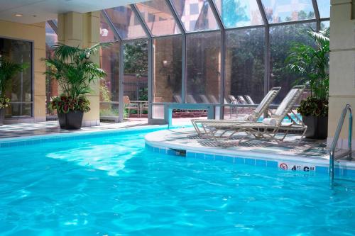 a swimming pool with chairs in a building at Hampton Inn & Suites Downers Grove Chicago in Downers Grove