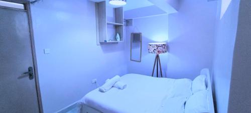 um quarto de hospital com uma cama branca e um chuveiro em The Purple Gem Airbnb -South B- Oak South Apartments em Nairobi