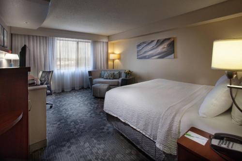 a hotel room with a bed and a couch at Courtyard by Marriott Fayetteville in Fayetteville