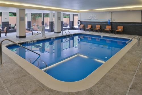 une piscine d'eau bleue dans un hôpital dans l'établissement Courtyard Atlanta Suwanee, à Suwanee